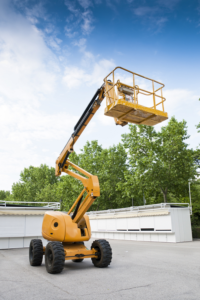 Boom Lift parked outside near trees and buildings