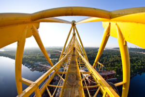 Arial view of a yellow boom lift with water and land below