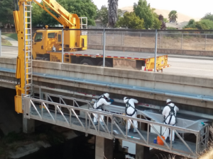 Yellow Aspen A 40 unit with 3 workmen in white inspecting bridge