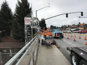 bridge inspection unit along side road-safety cones as traffric go by on the opposite direction