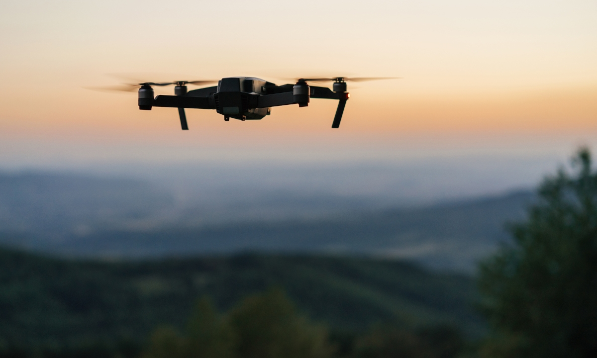 a drone in front of a sunset