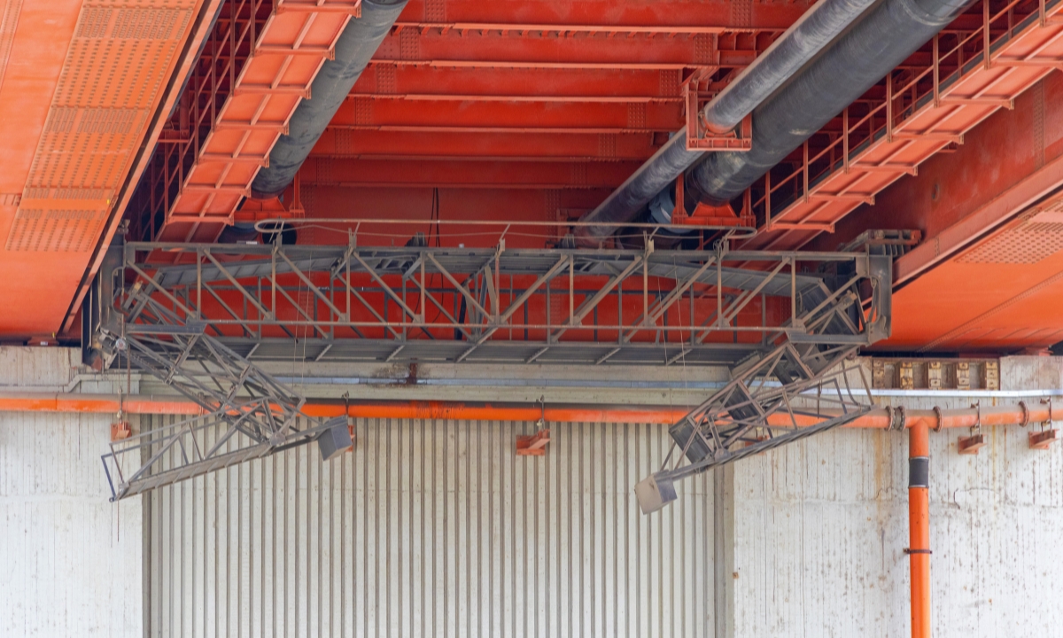 the underside of an orange bridge